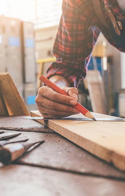 Carpenter working with equipment on wooden table in carpentry shop. woman works in a carpentry shop.